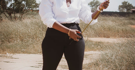 African female civil engineer wearing hard hat measuring outdoors with a tape. Ideal for industry or construction themes.