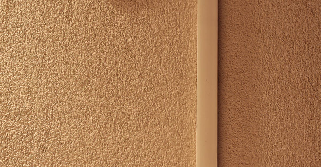 A minimalist indoor scene featuring a hygrometer mounted on a textured wall, indicating temperature and humidity.