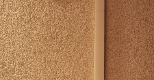 A minimalist indoor scene featuring a hygrometer mounted on a textured wall, indicating temperature and humidity.