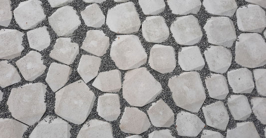 Top view of a geometric stone pathway with white rocks and gravel.