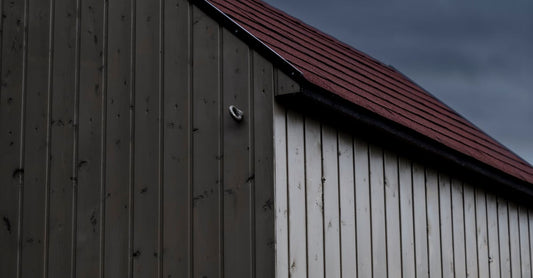 Low angle view of a modern wooden barn against a moody sky, featuring rustic charm.