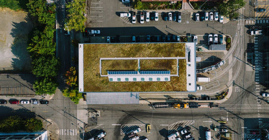 Aerial shot of a building with a green roof and solar panels in an urban Seattle setting.