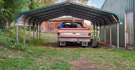 A Chevrolet truck loaded with items parked under a metal carport.