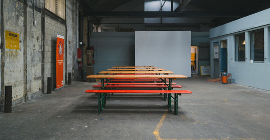 Empty industrial space with wooden benches, perfect for events or gatherings.
