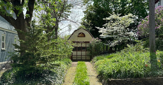 Beautiful garden path leading to a quaint shed surrounded by vibrant greenery.