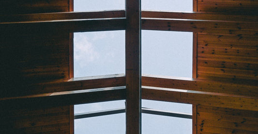 Wooden roof with open skylights allowing natural light to enter, showcasing architectural design.