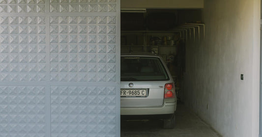 Partially open garage with parked car visible inside, featuring a modern sliding door design.