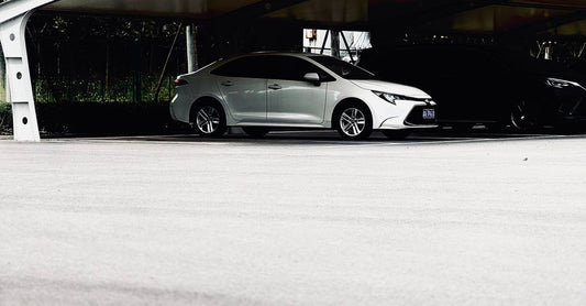 A modern car parked under a sleek canopy in an urban environment, offering ample parking space.