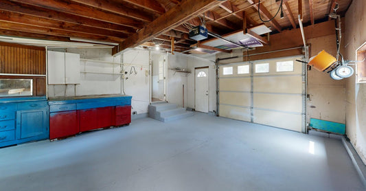 Empty garage with open space and colorful storage cabinets.