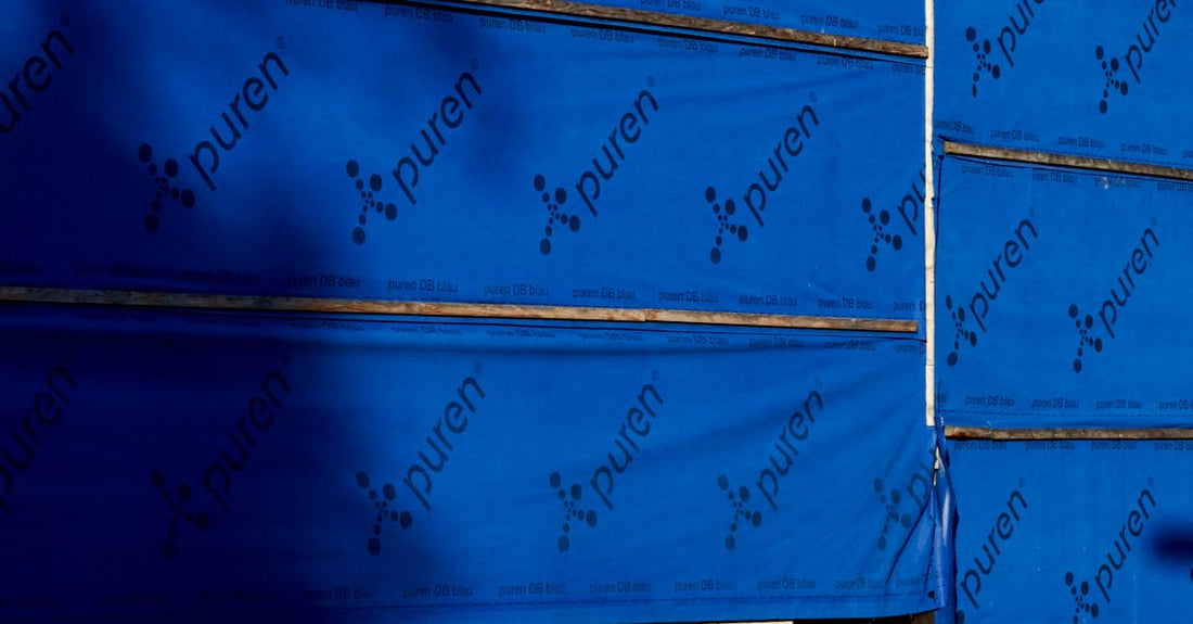 Building under construction with blue insulating wrap showing brand name puren