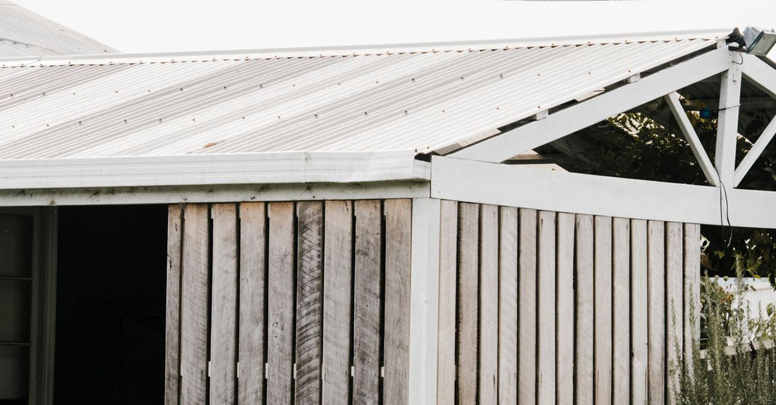 Charming rustic wooden shed with a barrel planter, set in an outdoor garden space, perfect for peaceful retreats.