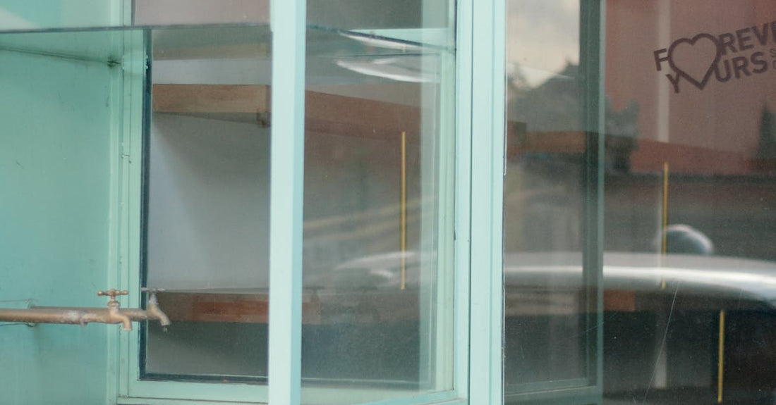 A glimpse of reflective glass display cabinets inside an empty store.