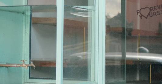 A glimpse of reflective glass display cabinets inside an empty store.