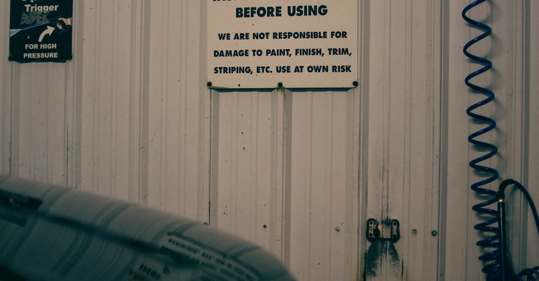 An indoor car garage scene with caution and warning signs on the wall.